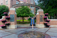 baduffy-260426-Tea's Grad Pics-6997-cap and open gown arms raised ankles crossed