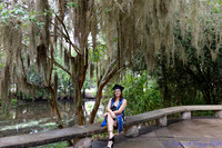 baduffy-260426-Tea's Grad Pics-7046-seated near water in sash and cap